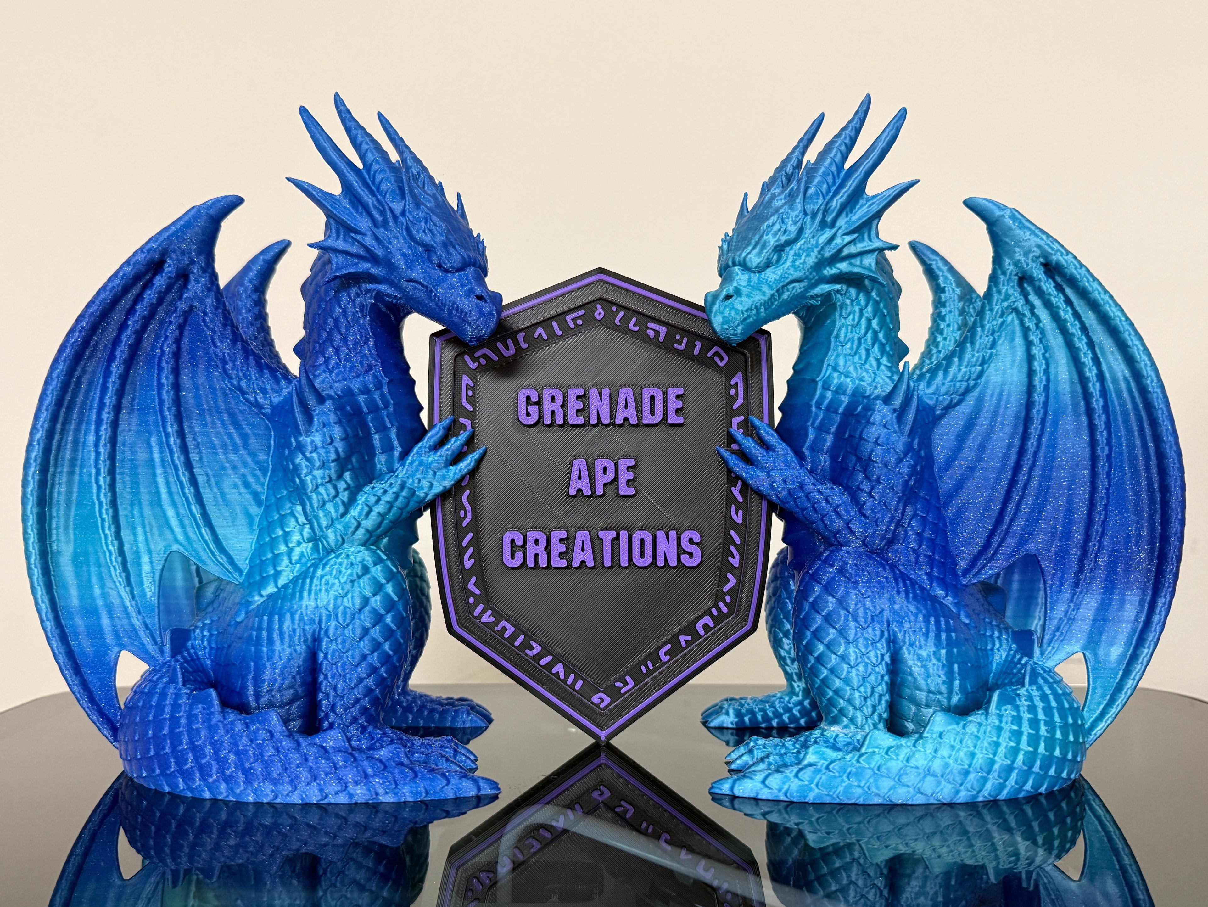 Blue dragon statues with a shield displaying 'Grenade Ape Creations' 